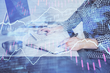 Double exposure of stock market chart with man working on computer on background. Concept of financial analysis.