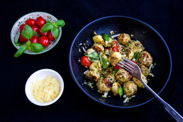 Gnocchi and chicken meatballs with pesto sauce, basil, tomatoes and nuts