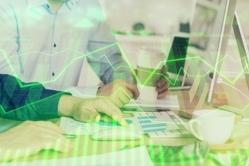 Multi exposure of chart with man typing on computer in office on background. Concept of hard work.