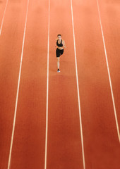 sportswoman running on road on stadium