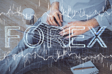 Forex graph with businessman working on computer in office on background. Concept of analysis. Double exposure.