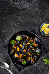 Vertical shot of cooked mussels on black background