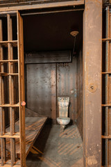 Cell in an abandoned prison showing an old combination sink and toilet.