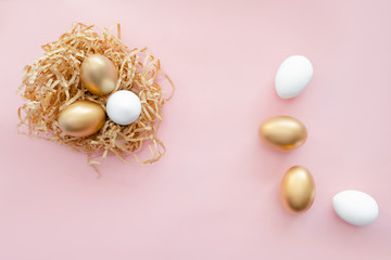 Easter golden decorated eggs in nest on white background . Minimal easter concept copy space for text. horizontal view, flatlay.