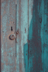 Wooden door with peeling paint and vintage handles with space for text