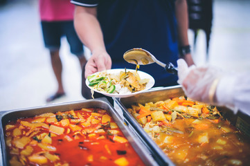 The donor gives warm food to the poor, concept of sharing food to the poor