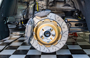 Automobile braking system. Ceramic carbon disk with perforation, ventilation and black calipers.