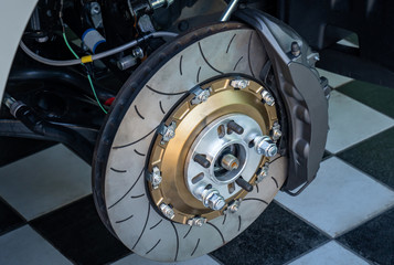Automobile braking system. Ceramic carbon disk with perforation, ventilation and black calipers.