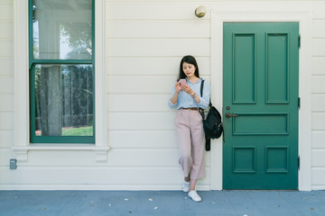 woman using phone texting standing on street