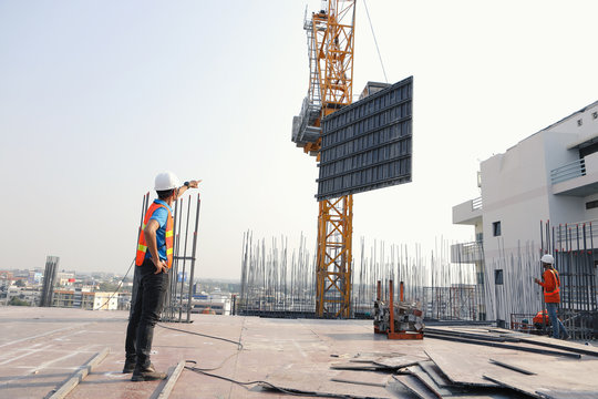 Two engineers work on the construction site. They are checking the progress of the work.