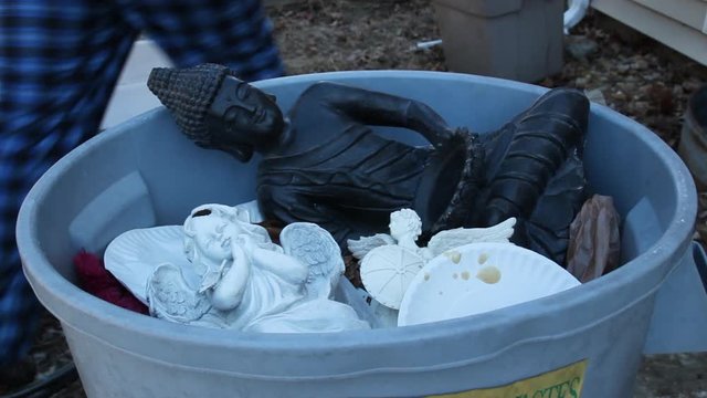 Angel Being tossed in the trash with other religious statues