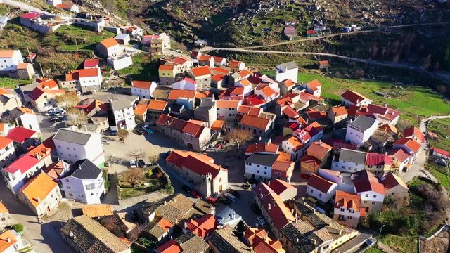 Aerial, drone shot, tilting over buildings in Sabugueiro village, sunny day, in Serra da estrela, Portugal
