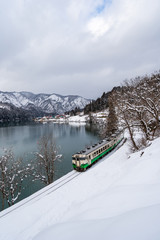 Beautiful landscape of Tadami line train across Tadami river in winter at Fukushima, Japan