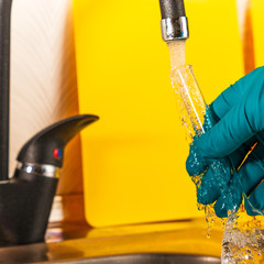 water purification specialist tap water pours into a glass flask.