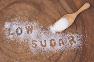 White sugar in wooden scoop and words