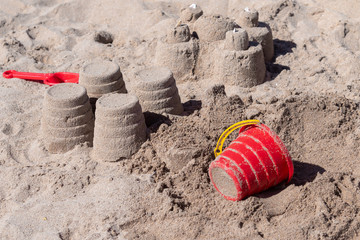 Bright plastic children's toys in the sand. The concept of a beach holiday for children.