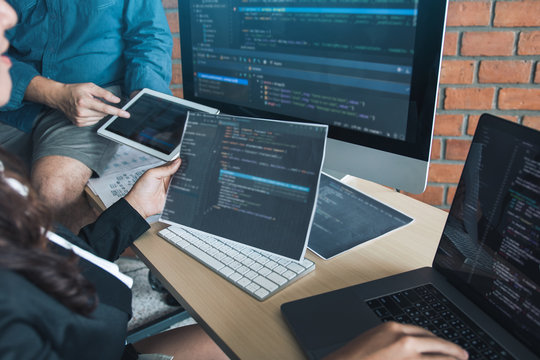 Two software developers are analyzing together about the code written into the program on the computer.