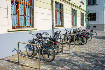 Fototapeta na wymiar Bycicles parked and locked on the stands made for them in Ljubljana