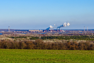 View on smoke pipes of the factory and agricultural field