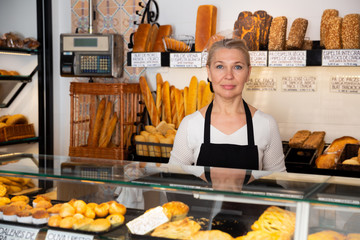 Saleswoman working at counter of bakery