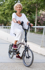 Obraz premium Elderly woman going to biking