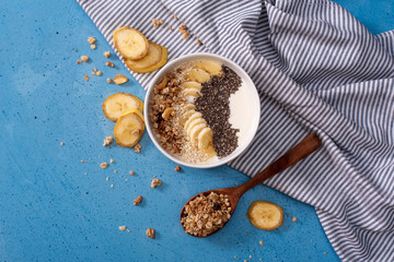 Healthy pineapple, mango smoothie bowl with coconut, bananas, blueberries and granola. Top view scene on a bright background.