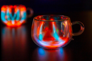 Red blue neon lightnings inside cup of bokeh lights and reflections.