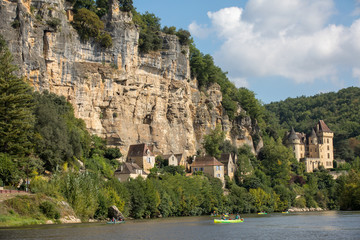  Canoeing on the river Dordogne at La Roque-Gageac and Chateau La Malartrie in the background. Aquitaine, France