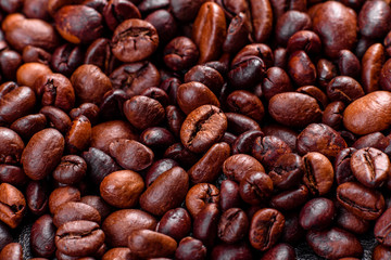 Grains of fresh roasted coffee close-up against a dark background