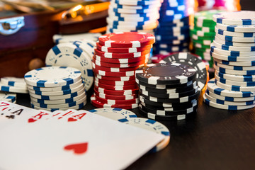 Gambling Concepts. Betting is a gamble for investors. Case full of chips, dollars and playing cards on a black background.