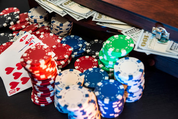 Poker chips and playing card on black table