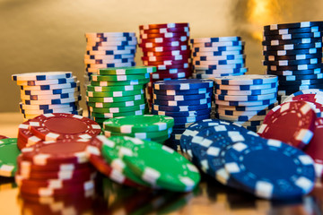 Stacks of poker chips isolated on golden background. Casino