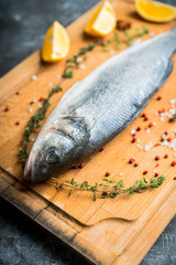Raw whole seabass fish on the rustic background. Selective focus. Shallow depth of field.