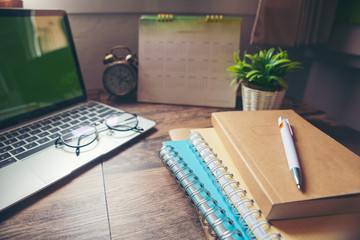 Planner and Calendar Concept . Desktop Calendar 2021, diary vintage clock laptop pen and eyeglasses placed on office desk. Notebook for Planner to set timetable,agenda and appointment.