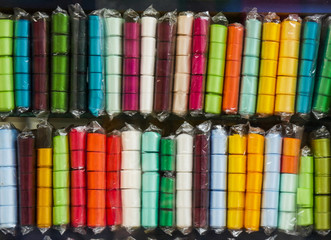 Colored textile ribbons for sale on needlework store shelves.