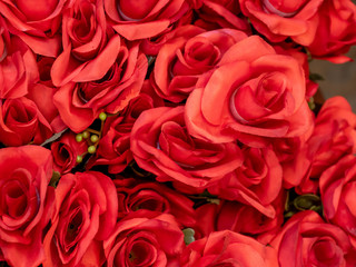 Close up imitation or artificial red rose flower background.