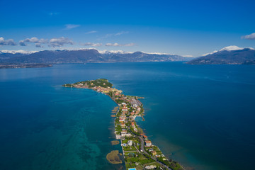 Sirmione town, Lake Garda, Italy. Aerial view of Sirmione high altitude.  In the background mountains in the snow and blue sky
