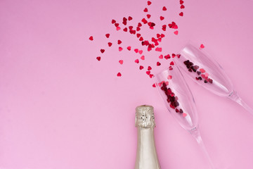 Celebration background - top view of two chrystal champagne glasses, bottle and  confetti
