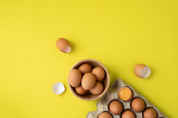 Raw eggs on yellow background.