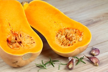 Pumpkin Butternut Liscia cut in half.   Yellow delicious pumpkin on wooden table.