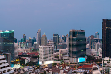 Fototapeta na wymiar Aerial cityscape of picturesque Bangkok at sunset from rooftop view. Panoramic sunrise skyline of the biggest city in Thailand. The concept of metropolis.