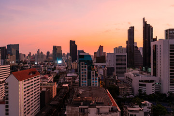Fototapeta premium Aerial cityscape of picturesque Bangkok at sunset from rooftop view. Panoramic sunrise skyline of the biggest city in Thailand. The concept of metropolis.