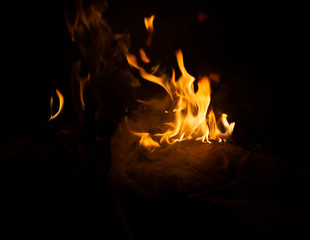 Fire flame caused by burning of wood on a black background