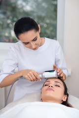 Obraz na płótnie Canvas Massage specialist wearing white uniform standing near patient