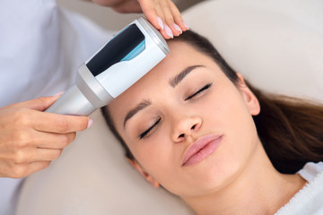 Fototapeta premium Close up of young woman enjoying ultrasound facial massage