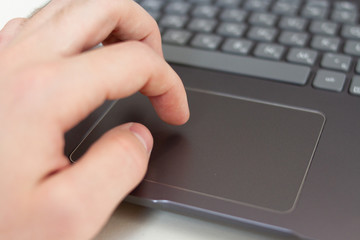 Close up of fingers on laptop silver touchpad