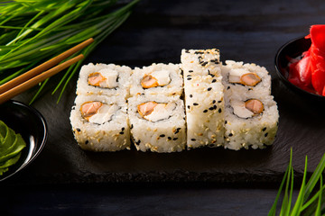 Set of sushi rolls with wasabi and ginger on a black background. Japanese oriental cuisine