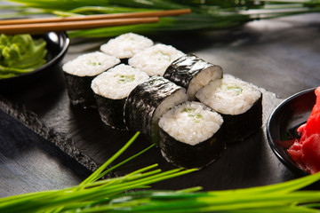 Set of sushi rolls with wasabi and ginger on a black background. Japanese oriental cuisine