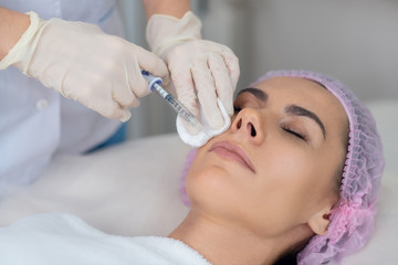 Close up of cosmetologist doing beauty injections for patient