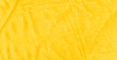 Vibrant yellow texture of binding fabric. Yellow textile background with natural folds. Close-up